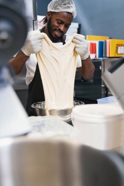 Mutfakta çalışan koruyucu elbiseli bir erkek.