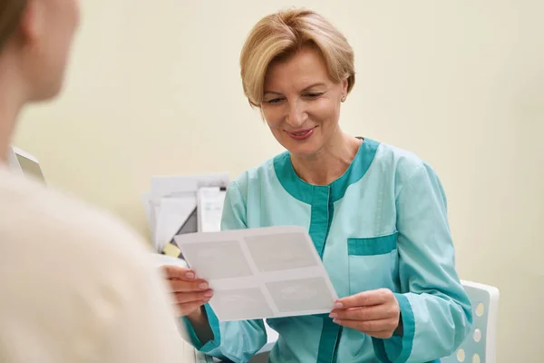 Positieve opgetogen gynaecoloog kijkend naar ultrageluid schot — Stockfoto