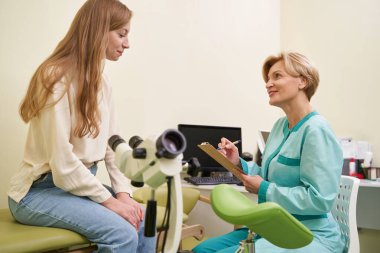 Genç hasta klinikte kanepede oturuyor.