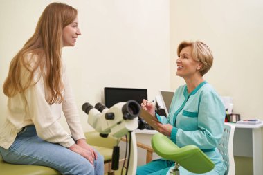 Uzun saçlı, keyifli bir kadın doktoruyla iletişim kuruyor.