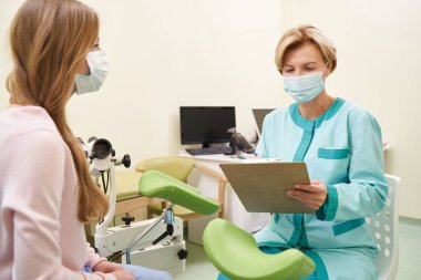 Çalışırken notlarına bakan ilgili bir pratisyen.