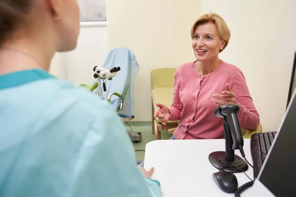 Mujer madura alegre visitando a su médico femenino — Foto de Stock
