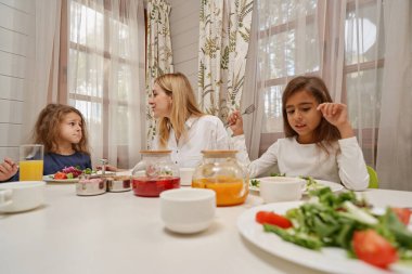 Çocuklarıyla iletişim kuran neşeli sarışın kadın.