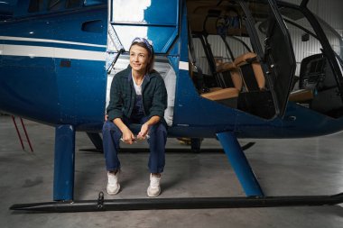 Esmer kadın mühendis hangarda dinleniyor.