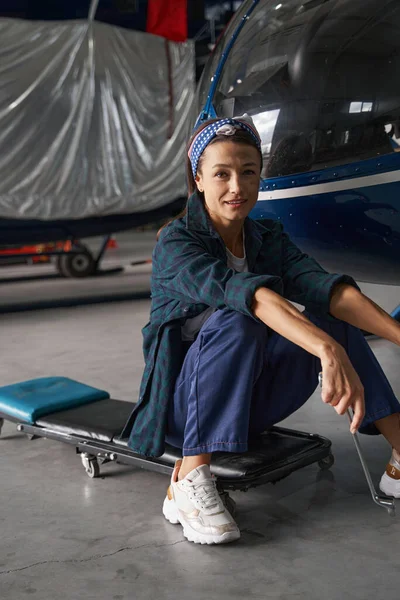 Mujer mecánica descansando después del avión de modernización en el hangar —  Fotos de Stock