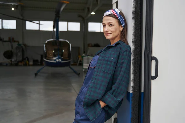 Morena feminina em geral posando na câmera de fotos na garagem da aviação — Fotografia de Stock