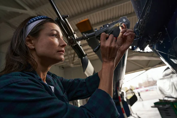 Morena caucasiana mulher ar quadro mecânico trabalhando na garagem da aviação — Fotografia de Stock