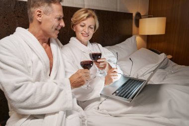 Sevimli çift, otel odasında şarapla eğleniyor.
