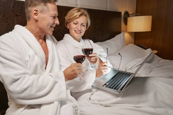 Sevimli çift, otel odasında şarapla eğleniyor. — Stok fotoğraf