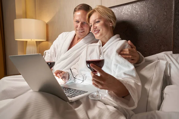 可爱的女人和英俊的男人在宾馆的床上看起来很开心 — 图库照片
