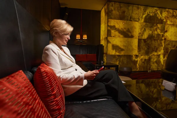 Attraktive blonde Dame vertreibt sich die Zeit in Hotellounge — Stockfoto