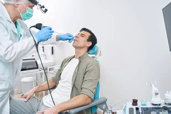 Доктор вивчає чоловіка з медичним інструментом у лікарні — стокове фото
