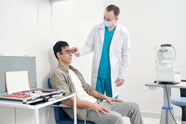 Doutor diagnosticando visão do homem no hospital — Fotografia de Stock