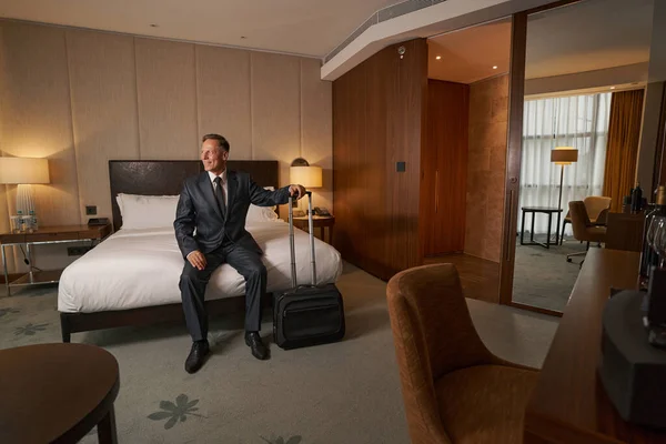 Амбициозный бизнесмен отдыхает в гостиничном номере во время рабочей поездки — стоковое фото