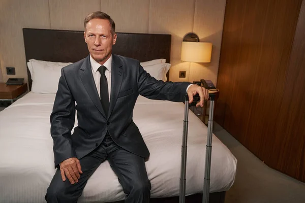 Entschlossener Unternehmer chillt auf Geschäftsreise im Hotelbett — Stockfoto