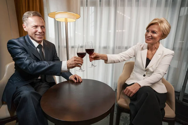 Colegas de negócios bebendo vinho no quarto de hotel juntos — Fotografia de Stock