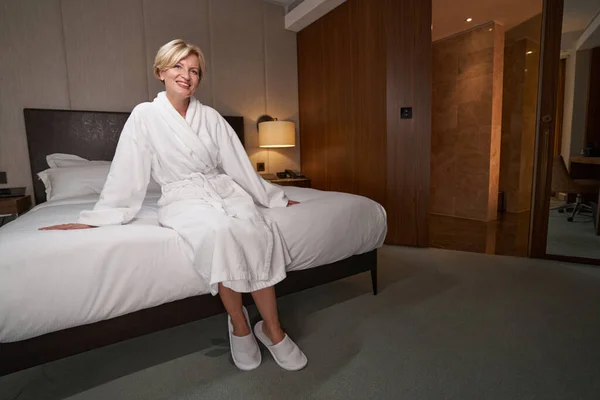 Мирная дама в белом халате наслаждается пребыванием в отеле — стоковое фото