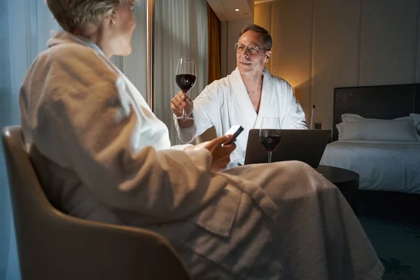 Hombre bebiendo vino con su colega en una habitación de hotel — Foto de Stock