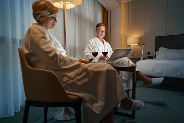 Nöjda affärspartner som kopplar av och arbetar på distans från hotellet — Stockfoto