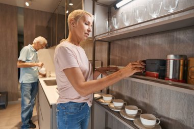 Siyah çayla kutu alan ciddi bir sarışın.