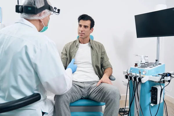 Médecin âgé communiquant avec le patient dans son bureau — Photo