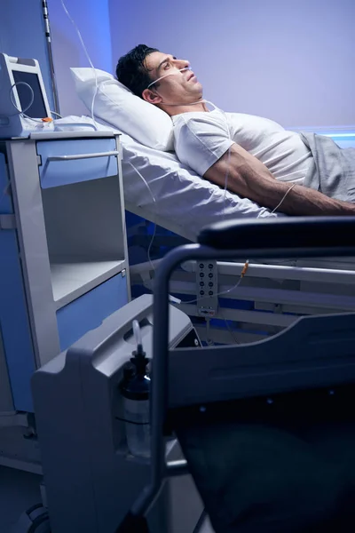 Sad man in white t-shirt resting after procedures — Stock Photo, Image