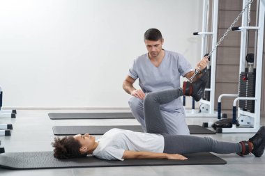Spor salonunda bacak egzersizi yapan bir bayan.