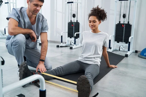 Américaine femme faire de l'exercice de jambe dans la salle de gym — Photo