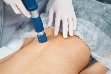 Kadın doktorla salonda masaj seansı yapıyor.