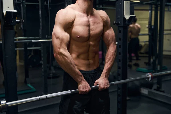 Foto focada em forte esportista levantando barbell — Fotografia de Stock