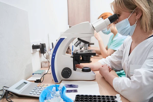 Médicos trabajando en el laboratorio con microscopios — Foto de Stock