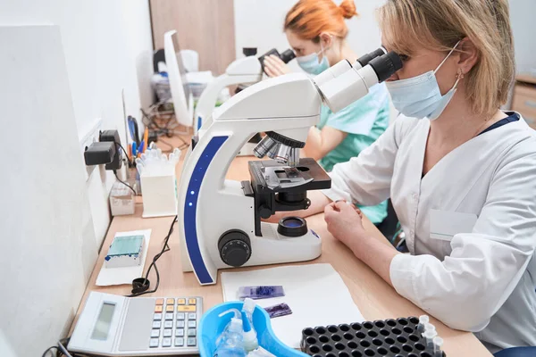 Lékařští pracovníci v laboratoři s mikroskopy — Stock fotografie