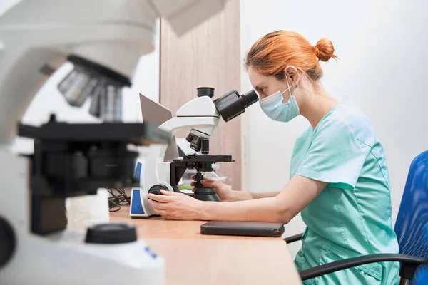 Vědec pracující v nemocnici s mikroskopem — Stock fotografie