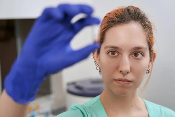 Lady zkontroluje baňku během práce v laboratoři — Stock fotografie