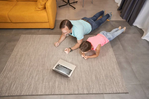 Hombre adulto está haciendo ejercicio en casa con adolescente en la sala de estar — Foto de Stock