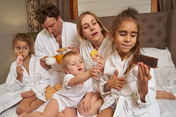 Parents with children eating together and having fun — Stock Photo, Image