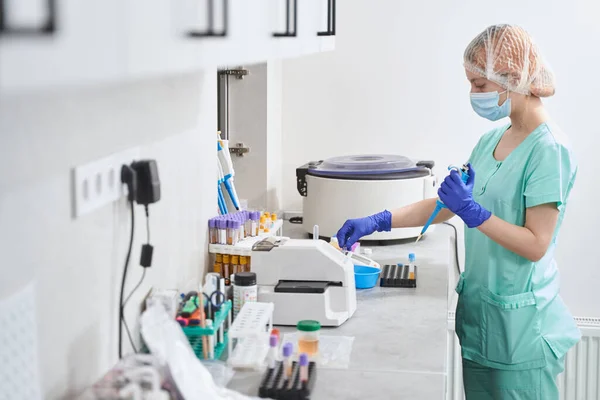 Žena v lékařském obleku pracující v laboratoři — Stock fotografie