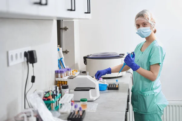 Žena v lékařském obleku tvrdě pracuje v laboratoři — Stock fotografie