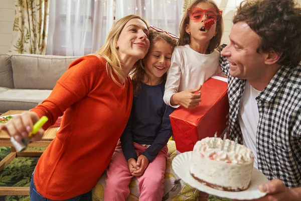 Família sorridente fazendo festa de aniversário com bolo — Fotografia de Stock