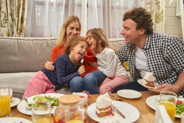 Portrait de parents souriants assis avec des filles — Photo