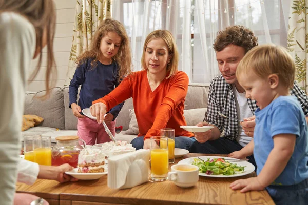 Ritratto di famiglia sorridente che mangia a casa — Foto Stock