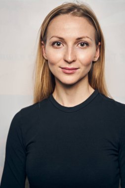 Sakin bir bayan, uzun sarı saçları var. Önüne bakıyor.