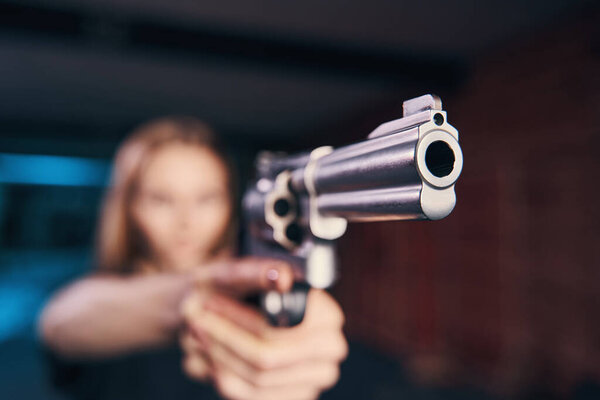 Experienced woman shooter holding a pistol with both hands