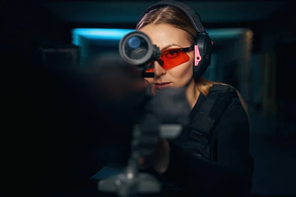 Mujer enfocada disparando una ametralladora con una mira telescópica —  Fotos de Stock