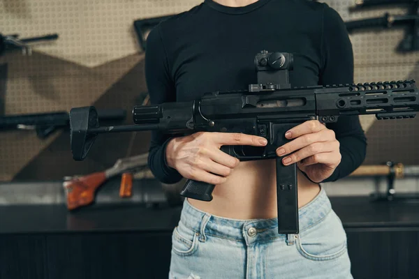 Vendedora experimentada mostrando una nueva arma en la tienda de armas —  Fotos de Stock