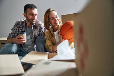 Açılmamış eşyaların arasında oturan çekici bir çift.