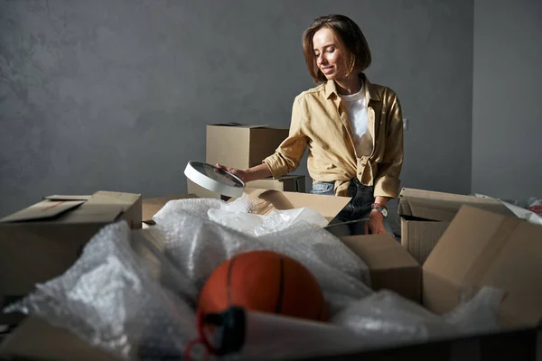 Young woman unpacking things in her new flat — Stock Photo, Image