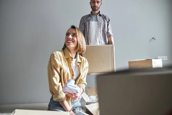 Mujer alegre y su marido serio en un piso nuevo — Foto de Stock