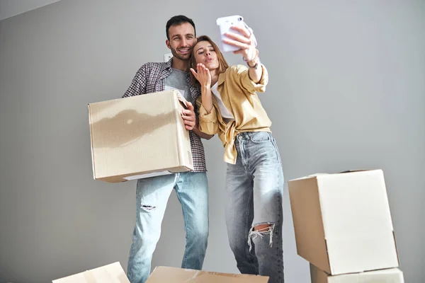 Dos jóvenes tomando selfies contra la pared — Foto de Stock