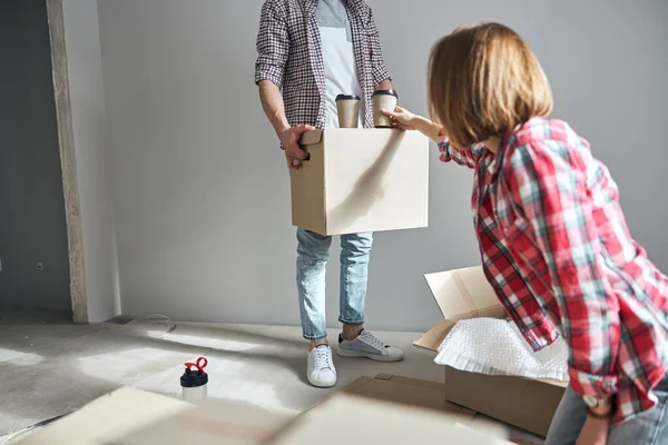 Man serving a hot beverage placed on a cardboard box — Stock Photo, Image